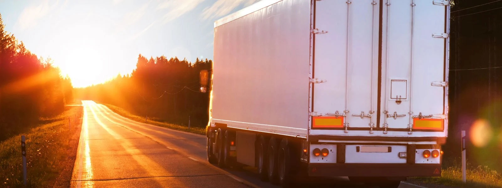 Truck traveling on a highway at sunset